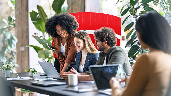 Gruppe bespricht im Büro Inhalte auf einem Laptop